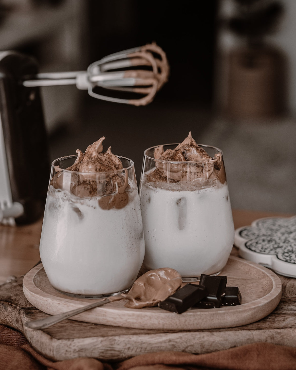 Whipped coffee drinks and chocolate on a wooden tray, edited with brown Lightroom presets