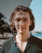 Before-and-after outdoor portrait showing subdued blues and neutral skin tones with Moody Brown Lightroom presets